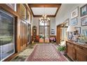 Grand foyer boasts high ceilings, wood beams, tile floor, chandelier and large windows offering natural light at 10614 Winterwood, Carmel, IN 46032