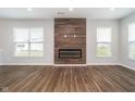 Spacious living room with electric fireplace, large windows providing natural light, and elegant hardwood flooring throughout at 10628 Mangrove Dr, Indianapolis, IN 46239