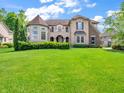 This two-story residence features a turret, balcony, and a blend of brick and stone accents on a green lawn at 10792 Harbor Bay Dr, Fishers, IN 46040