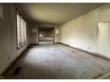 Bare living room with peeling paint, damaged walls, and boarded-up windows at 11830 Gray Rd, Carmel, IN 46033