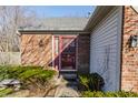Charming entryway featuring a red door, brick accents, and well-maintained landscaping at 11930 Titania Cir, Indianapolis, IN 46236