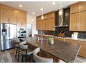 Modern kitchen featuring stainless steel appliances, a large island, and stone tile backsplash at 14049 Trueblood Ln, Carmel, IN 46033