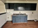 Functional laundry area with painted cabinets, sink and laminate flooring at 151 N 8Th Ave, Beech Grove, IN 46107