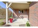 Inviting front porch with brick exterior, decorative seating, and a charming, covered entrance at 153 Monticello Ct, Noblesville, IN 46060