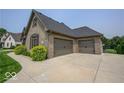 A home featuring a spacious three-car garage and an extra wide concrete driveway in front of the home at 1740 Golden Field Dr, Greenwood, IN 46143