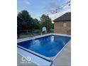 In-ground swimming pool with an automatic safety cover and patio furniture in a landscaped backyard at 1740 Golden Field Dr, Greenwood, IN 46143