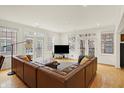 Sun-filled living room with a large sectional sofa, hardwood floors, and multiple windows with courtyard views at 226 N Cleveland St # 226E, Indianapolis, IN 46204