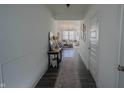 Bright hallway with wood floors leading to a cozy living room with plenty of natural light at 2349 Dixon Creek Dr, Whitestown, IN 46075