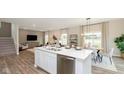 Open-concept kitchen with stainless steel appliances, a large island, and seamless flow to the dining and living areas at 250 Evening Bay Ct, Pendleton, IN 46064