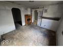 A glimpse of the living room showing worn flooring and a vintage mantle at 312 N Grafton Ave, Muncie, IN 47303