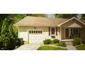 Inviting home with an attached garage, red shutters, and lovely landscaping with green bushes and trees at 338 N Darlington St, Jamestown, IN 46147