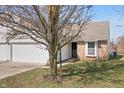 View of the front of this single-story home featuring a two-car garage, brick accents, and a well-maintained front yard at 7164 Long Shore Cir, Indianapolis, IN 46217