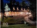 Charming two-story home with a covered porch illuminated at night, decorated with festive holiday lighting at 7540 S Mooresville Rd, Indianapolis, IN 46221