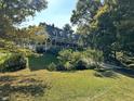 Charming two-story home with a covered porch surrounded by lush green trees in the neighborhood at 7540 S Mooresville Rd, Indianapolis, IN 46221