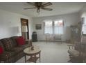 Bright living room featuring neutral carpet, ceiling fan, and natural lighting at 805 Stewart Rd, Anderson, IN 46012