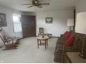 Comfortable living room featuring neutral carpet, ceiling fan, and large furniture set at 805 Stewart Rd, Anderson, IN 46012