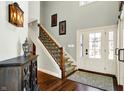 Inviting foyer featuring beautiful hardwood floors, staircase, and a striking front door at 86 Cricket Knoll Ln, Carmel, IN 46033