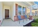 Inviting front porch with red brick accents, and two chairs perfect for relaxing at 887 Tuxedo Dr, Westfield, IN 46074