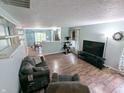 Open-concept living room with wood floors, neutral paint, and an eat-in kitchen at 11403 Fairweather Pl, Indianapolis, IN 46229