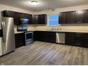 Well-lit kitchen featuring stainless steel appliances and dark cabinetry at 125 Hilltop Farms Blvd, Whiteland, IN 46184