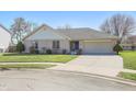 Charming ranch-style home with a brick facade, attached garage, and manicured front lawn on a sunny day at 2231 Reston Ln, Columbus, IN 47203