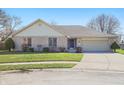 Charming ranch-style home with a brick facade, attached garage, and manicured front lawn on a sunny day at 2231 Reston Ln, Columbus, IN 47203