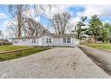 Cozy single-story home with a long gravel driveway and a well-maintained lawn at 2305 S Rybolt Ave, Indianapolis, IN 46241