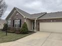 Inviting home with brick accents, well-manicured landscaping, attached garage, and a concrete driveway at 2610 Big Bear Ln, Indianapolis, IN 46217
