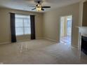 Spacious living room with neutral carpet, large window, and view into the sunroom at 2610 Big Bear Ln, Indianapolis, IN 46217