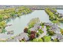 Scenic aerial view of homes nestled along a tranquil lake, surrounded by lush greenery and mature trees at 3539 Clearwater Cir, Indianapolis, IN 46240