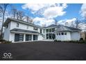 Elegant white home featuring a black metal roof, a three-car garage and an extra turret at 395 Breakwater Dr, Fishers, IN 46037