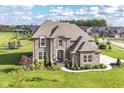Gorgeous brick home showcases manicured lawns, beautiful landscaping, and elegant architectural design in a Gathering-friendly neighborhood at 4255 Kettering Dr, Zionsville, IN 46077