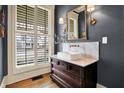 Stylish powder room with a modern marble countertop, decorative lighting, and traditional mirror at 450 W Ash St, Zionsville, IN 46077