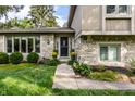 Close-up of a home's stone exterior, beautiful landscaping, and a charming front entrance at 4528 Brookshire Pkwy, Carmel, IN 46033