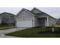 Charming gray home featuring a white garage door and front door, complemented by fresh landscaping at 5138 Modernist Blvd, Indianapolis, IN 46237