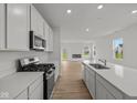 Modern kitchen with white cabinets, stainless steel appliances and center island at 5138 Modernist Blvd, Indianapolis, IN 46237