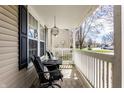 Cozy front porch with comfortable chairs, a small table, and white railing, perfect for relaxing at 5687 N Plymouth Ct, McCordsville, IN 46055
