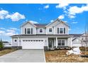 Beautiful two-story home with gray siding, front lawn, and a two car garage at 5777 Greenbrier Ct, Brownsburg, IN 46112