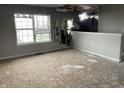 View of damaged living room with holes in wall, damage to the ceiling, and water damage throughout at 6009 Tammin Dr, Indianapolis, IN 46254