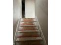 Interior view of a damaged stairway with missing carpet and exposed wood, indicative of needed repairs at 6009 Tammin Dr, Indianapolis, IN 46254