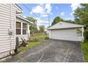 Detached garage with a paved driveway and chain link fence on a sunny day at 633 Fletcher Ln, Beech Grove, IN 46107