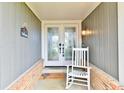 A welcoming front porch features double doors, a rocking chair, and a welcome mat at 695 Valley Oaks Rd, Greenwood, IN 46143
