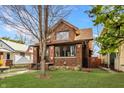 Quaint brick home with a green lawn and mature trees adding to the curb appeal at 741 Dequincy St, Indianapolis, IN 46201