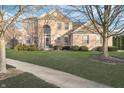 Two-story brick home with arched entryway, green lawn and mature trees at 8253 Belcrest Ct, Indianapolis, IN 46256