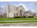 View of the rear exterior, with a brick facade, chimney and well-kept lawn at 8253 Belcrest Ct, Indianapolis, IN 46256
