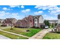 Picture of a brick home with an attached garage, driveway, manicured lawns, and mature trees at 9253 Windrift Way, Zionsville, IN 46077