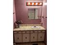 A charming bathroom with pink floral wallpaper, a vanity sink, a mirror, and a decorative vase at 930 N Ritter Ave, Indianapolis, IN 46219