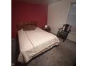 A quaint bedroom featuring a full-size bed, a nightstand, an antique rocking chair, and a window at 930 N Ritter Ave, Indianapolis, IN 46219