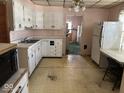 Kitchen with white cabinetry, vintage appliances, and dated flooring at 942 N Oxford St, Indianapolis, IN 46201