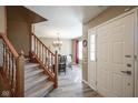 Inviting entryway featuring wood-look floors, a staircase, and a view into the dining area at 10212 Ironway Dr, Indianapolis, IN 46239
